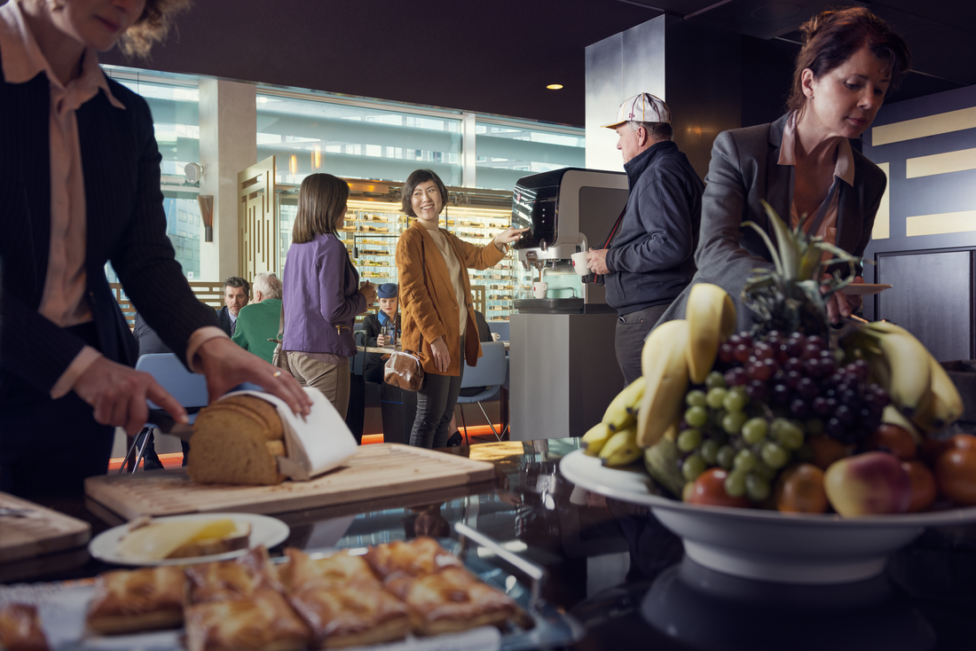mensen eten en pakken koffie in de ontbijtzaal van een hotel